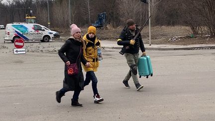 Un combattant ukrainien aide des civils à évacuer la ville d'Irpin sous les bombardements. (GILLES GALLINARO / RADIO FRANCE)