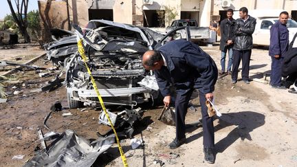 Des hommes des services de sécurité inspectent le site d'un attentat suicide à la voiture piégée à Zliten (Libye) le 7 janvier 2016. (MAHMUD TURKIA / AFP)