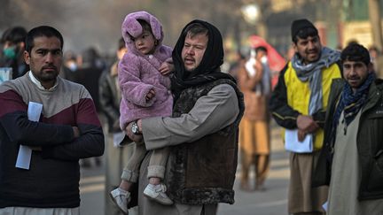 Des habitants de Kaboul (Afghanistan) font la queue à l'entrée d'un guichet pour passeport, dimanche 19 décembre 2021. (MOHD RASFAN / AFP)