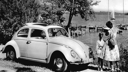 Inventée sous Hitler et développée après guerre, la Coccinelle de Volkswagen est le symbole du miracle allemand et de son industrie (ici, une famille allemande et sa voiture au bord d'un lac à Berlin en 1965).