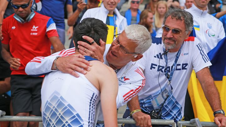 Guy Ontanon, manager de la performance du para athlétisme à la Fédération handisport, et Olivier Deniaud, team leader de l'équipe de France, félicitent Valentin Bertrand après sa médaille de bronze sur le saut en longueur T37 lors des Mondiaux de para athlétisme, le 15 juillet 2023. (FLORENT-PERVILLE)