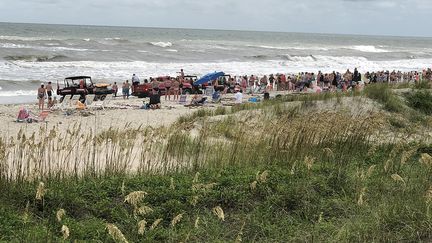 Des vacanciers forment une chaîne humaine pour sauver des baigneurs sur la plage de Emerald Isle en Caroline du Nord (Etats-Unis), le 25 juillet 2018. (SHANE GENTRY)