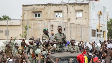 Des militaires maliens sont acclamés dans les rues de Bamako, le 18 août 2020, après le coup d'Etat militaire qui a renversé le président&nbsp;Ibrahim Boubacar Keïta. (STRINGER / AFP)