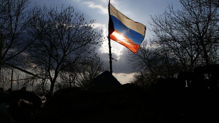 Un drapeau russe flotte sur une barricade &eacute;rig&eacute;e devant la base a&eacute;rienne ukrainienne &agrave; Kramatorsk (Ukraine), le 15 avril 2014. (MARKO DJURICA / REUTERS)