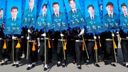 Les gardes d'honneur sud-coréens défilent dans le centre-ville de Daejeon, le 26 Mars 2013. Ils portent des banderoles à l’effigie des 46 marins morts en 2010, lorsque le navire de guerre le «Cheonan» a coulé. (AFP PHOTO / POOL / KIM Jae-Hwan   )