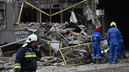 Des secouristes ukrainiens travaillent à l'extérieur d'un immeuble résidentiel endommagé par des missiles russes à Kiev, le 26 juin 2022. (SERGEI SUPINSKY / AFP)