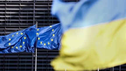 Les drapeaux de l'Union européenne et de l'Ukraine devant le siège du Conseil européen à Bruxelles, le 16 mai 2022. (KENZO TRIBOUILLARD / AFP)