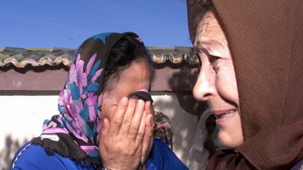 Des voisins pleurent dans le village de Tipaza, à quelque 70 kilomètres au sud-ouest d’Alger, le 13 mars 2001, après un massacre. (HZ / AFP)