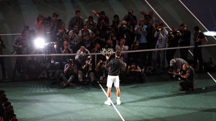 Novak Djokovic brandit son troph&eacute;e devant la presse, apr&egrave;s sa victoire au Masters de Paris-Bercy, le 3 novembre 2013. (CHARLES PLATIAU / REUTERS)