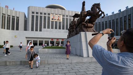 Des touristes se photographient devant&nbsp;le palais des enfants Mangyongdae à Pyongyang, en Corée du Nord, le 26 juillet 2018. (ED JONES / AFP)