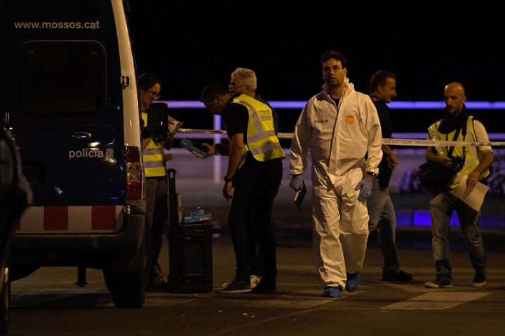 Les enquêteurs sur la zone où un véhicule a foncé sur la foule, à Cambrils (Espagne), jeudi 17 août 2017, avant de se retourner. (LLUIS GENE / AFP)