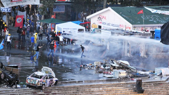 La police utilise un canon &agrave; eau et des gaz lacrymog&egrave;nes pour disperser les manifestants install&eacute;s dans le parc Gezi, pr&egrave;s de la place Taksim d'Istanbul (Turquie), le 15 juin 2013. (OZAN KOSE / AFP)