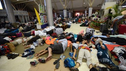 Des touristes étrangers dans l'attente de leur départ, à l'aéroport de Lombok, en Indonésie, le 6 août 2018. (SONNY TUMBELAKA / AFP)