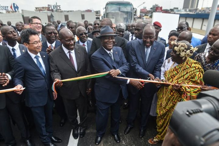 Le président ivoirien Alassane Ouattara, accompagné de plusieurs membres de son gouvernement et du chargé d’affaires de l’ambassade du Japon en Côte d’Ivoire, inaugure l’échangeur de la jonction Solibra, dans la banlieue d’Abidjan, dont la construction a été cofinancée par la Côte d’Ivoire et le Japon, le 16&nbsp;décembre 2019.  (SIA KAMBOU/AFP)