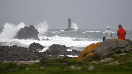 Des personnes regardent la mer agitée devant le phare du Four, dans le Finistère, le 2 novembre 2019. (DAMIEN MEYER / AFP)