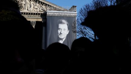 Un immense portrait de Johnny Hallyday a été installée sur la façade de l'église de la Madeleine. Une scène a été aménagée au pied de l'église, pour permettre à des musiciens de rendre hommage au chanteur en musique.&nbsp; (PASCAL ROSSIGNOL / REUTERS)