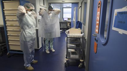 Une équipe médicale de l'hôpital de Strasbourg (Bas-Rhin) s'apprête à entrer dans une chambre de soins intensifs accueillant un patient Covid-19, le 22 octobre 2020.&nbsp; (FREDERICK FLORIN / AFP)