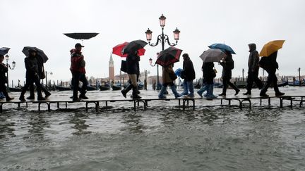 Des personnes traversent la place Saint-Marc, le 12 novembre 2019 à Venise (Italie). (MANUEL SILVESTRI / REUTERS)