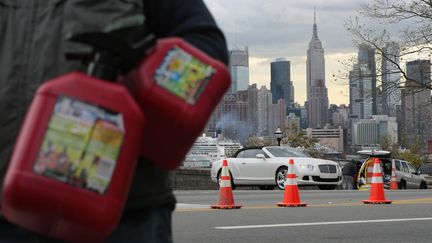 Un homme attend pr&egrave;s d'une station-service avec des jerricans pour acheter de l'essence, &agrave; Union City, dans le New Jersey, Etat voisin de la ville de New York, le 2 novembre 2012. (EDUARDO MUNOZ / REUTERS)