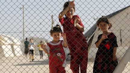 Des r&eacute;fugi&eacute;s y&eacute;zidis derri&egrave;re les grillages, le 20 juin 2015, en attendant l'arriv&eacute;e de l'envoy&eacute;e sp&eacute;ciale des Nations unies pour les r&eacute;fugi&eacute;s Angelina Jolie, dans le camp de Mardin (sud de la Turquie) accueillant des Syriens et des Irakiens.&nbsp; (UMIT BEKTAS / REUTERS )