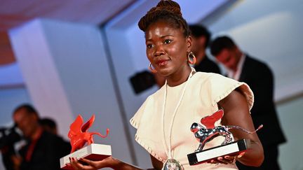 La réalisatrice française Alice Diop pose avec ses deux récompenses lors de la Mostra de Venise, à Venise (Italie), le 10 septembre 2022. (ANDREAS SOLARO / AFP)