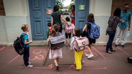 Des parents et des enfants arrivent à l'école élémentaire publique Jules Julien, le 22 juin à Toulouse, en Haute-Garonne. (photo d'illustration) (LIONEL BONAVENTURE / AFP)