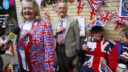 Margaret Tyler et David Jones,&nbsp;fans de la famille royal, ont rev&ecirc;tu les couleurs de la couronne devant la maternit&eacute;&nbsp;St. Mary's de Londres, le 2 mai 2015. (TOLGA AKMEN / ANADOLU AGENCY / AFP)