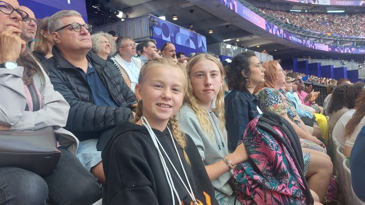 Maéline, in the foreground, and her sister Gwendoline attend athletics events at the Paris 2024 Olympic Games, with Secours populaire. Illustration. (DELPHINE GOTCHAUX / RADIOFRANCE)