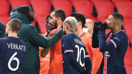 Les deux joueurs du PSG Kilian Mbappé et Neymar aux côtés de joueurs du&nbsp;Basaksehir Istanbul, après la suspension du match de ligue des champions, mardi 8 décembre 2020. (FRANCK FIFE / AFP)