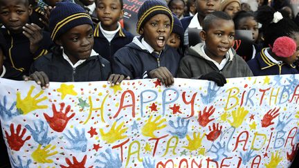 Chaque anniversaire de celui que les Sud-Africains surnomment "Madiba" est l'occasion de d&eacute;monstration d'affection, comme ici avec ces &eacute;l&egrave;ves de l'&eacute;cole primaire Batsogile de Soweto, le 18 juillet 2012. (STEPHANE DE SAKUTIN / AFP)