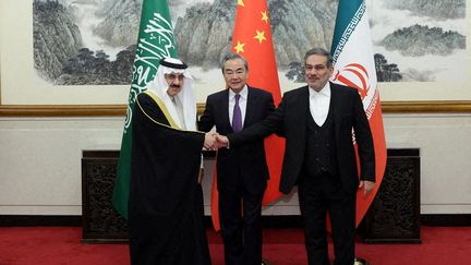 Le responsable saoudien de la sécurité nationale Musaid Al Aiban rencontre son homologue iranien Ali Shamkani, sous l'égide de Wang Yi, chef de la diplomatie chinoise, le 10 mars 2023 à Pékin. (CHINESE FOREIGN MINISTRY / ANADOLU AGENCY / AFP)