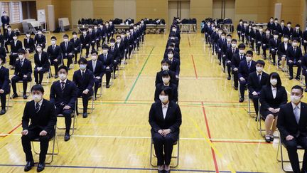 Ces personnes viennent d'être recrutées par la sosciété de métro d'Osaka (Japon). Elles assistent à la cérémonie d'entrée dans l'entreprise en respectant les règles de distanciation sociale, le 1er avril 2020. (MAKOTO KONDO / YOMIURI)