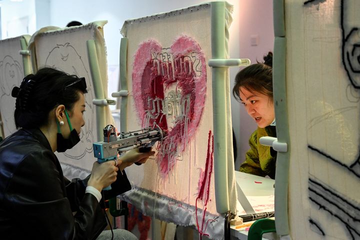 Les jeunes Chinois accros au tuftage, l'artisanat anti-stress&nbsp; dans un atelier à Pékin en Chine&nbsp;en avril 2022 (JADE GAO / AFP)