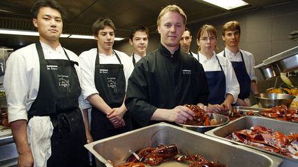 Le chef &eacute;toil&eacute;&nbsp;Nicolas Le Bec (au c.) entour&eacute; de son &eacute;quipe dans l'un de ses anciens restaurants, La Cour des loges,&nbsp;le 14 f&eacute;vrier 2002 &agrave; Lyon (Rh&ocirc;ne). (JEAN-PHILIPPE KSIAZEK / AFP)