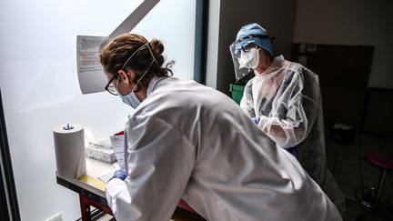 Des employées d'un laboratoire médical participent à une campagne de dépistage organisée lors d'un "drive-test' à Villefranche-sur-Saône (Rhône), le 3 avril 2020. (ANTOINE MERLET / HANS LUCAS / AFP)