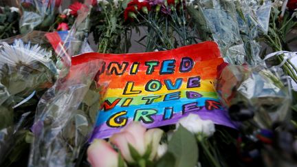 Des fleurs et un dessin posés en hommage aux victimes de la tuerie à Orlando (Floride) devant l'ambassade américaine de Moscou (Russie), le 13 juin 2016. (MAXIM ZMEYEV / REUTERS)