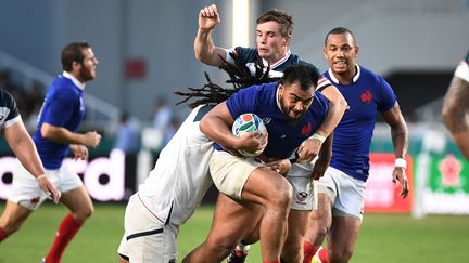 Le Français Emerick Setano (au centre) est taclé par les Américains&nbsp;AJ MacGinty et&nbsp;Joseph Taufete'e, mercredi 2 octobre 2019 lors du deuxième match de poule du XV de France lors de la Coupe du monde de rugby, à&nbsp;Fukuoka (Japon). (FRANCK FIFE / AFP)