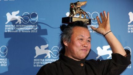 Le r&eacute;alisateur cor&eacute;en Kim Ki-Duk tenant son Lion d'or glan&eacute; &agrave; Venise&nbsp;pour son film "Pieta" lors du 69e festival du cin&eacute;ma, le 8 septembre 2012. (TIZIANA FABI / AFP)