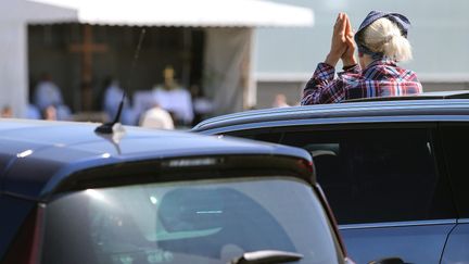 Une fidèle prie depuis sa voiture, le 17 mai 2020 à Châlons-en-Champagne (Marne). (FRANCOIS NASCIMBENI / AFP)