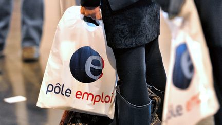 Des personnes patientent devant un stand de P&ocirc;le emploi, lors d'un salon pour l'emploi organis&eacute; &agrave; Arras (Pas-de-Calais), le 18 octobre 2012. (PHILIPPE HUGUEN / AFP)