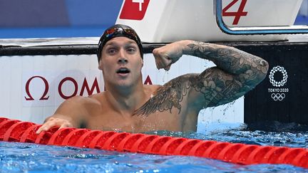 Caeleb Dressel montre les muscles après sa victoire, et son record du monde, en finale du 100 mètres papillon, le 31 juillet à Tokyo.&nbsp; (JONATHAN NACKSTRAND / AFP)