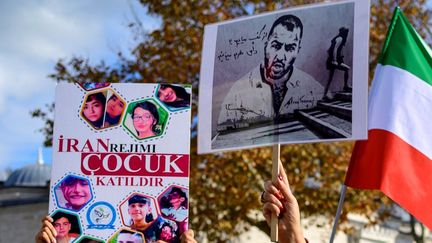 Des manifestants&nbsp;portant des portraits du rappeur iranien Toomaj Salehi et&nbsp;ceux d'enfants tués lors des manifestations en Iran, lors d'un rassemblement de soutien aux femmes iraniennes à Istanbul, le 22novembre 2022. (YASIN AKGUL / AFP)