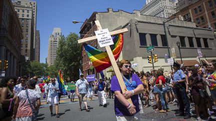 Un membre de l'Église communautaire métropolitaine porte une croix marquée des mots "En mémoire des victimes du club Pulse", à Philadelphie (Pennsylvanie), le 12 juin 2016. (JESSICA KOURKOUNIS / GETTY IMAGES)