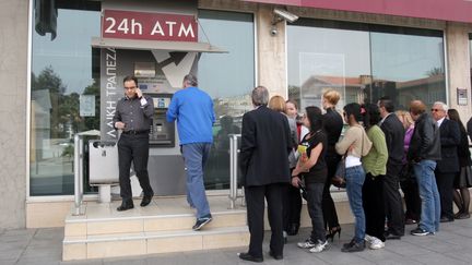 Une file d'attente devant un distributeur de la banque Laiki, le 21 mars 2013 &agrave; Nicosie (Chypre). (HASAN MROUE / AFP)