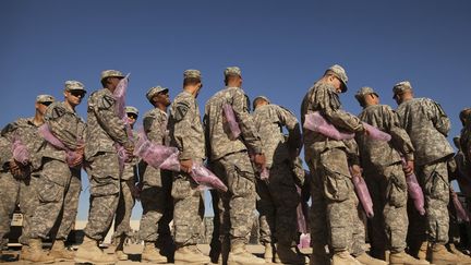 Des soldats bas&eacute;s au Koweit font la queue avec leur arme empaquet&eacute;e afin de les renvoyer aux Etats-Unis, le 19 d&eacute;cembre 2011. (LUCAS JACKSON / REUTERS)