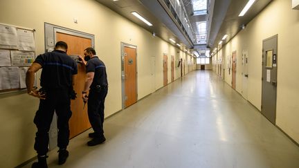 Des gardiens de prison ferment une porte dans un couloir de la prison de la Sante à Paris, le 6 novembre 2020. Photo d'illustration. (BERTRAND GUAY / AFP)