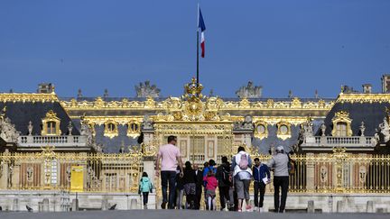 Des visiteurs se pressent devant l'entrée du Château de Versailles (Yvelines), le 18 mai 2015. (KENZO TRIBOUILLARD / AFP)