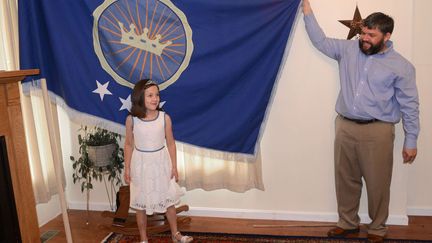 Jeremiah Heaton et sa fille de 7 ans, Emily, montrent le drapeau de leur autoproclam&eacute; "Royaume du Nord-Soudan" &agrave; leur domicile d'Abingdon (Virginie,&nbsp;Etats-Unis), le 2 juillet 2014. (DAVID CRIGGER / AP / SIPA)