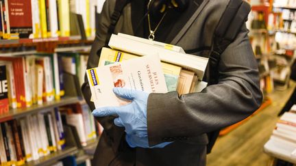 Un homme prend des livres dans une librairie le 11 mai 2020 à Paris. (OLIVIER CORSAN / MAXPPP)