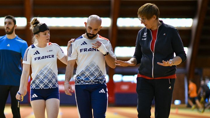 Sylvie Talmant, entraîneure de l'équipe de France de para athlétisme, discute avec Tiffany Logette-Lods et son guide Erwan Le Rolland lors d'une session d'entraînement à l'Insep, le 7 février 2023. (DIDIER ECHELARD)